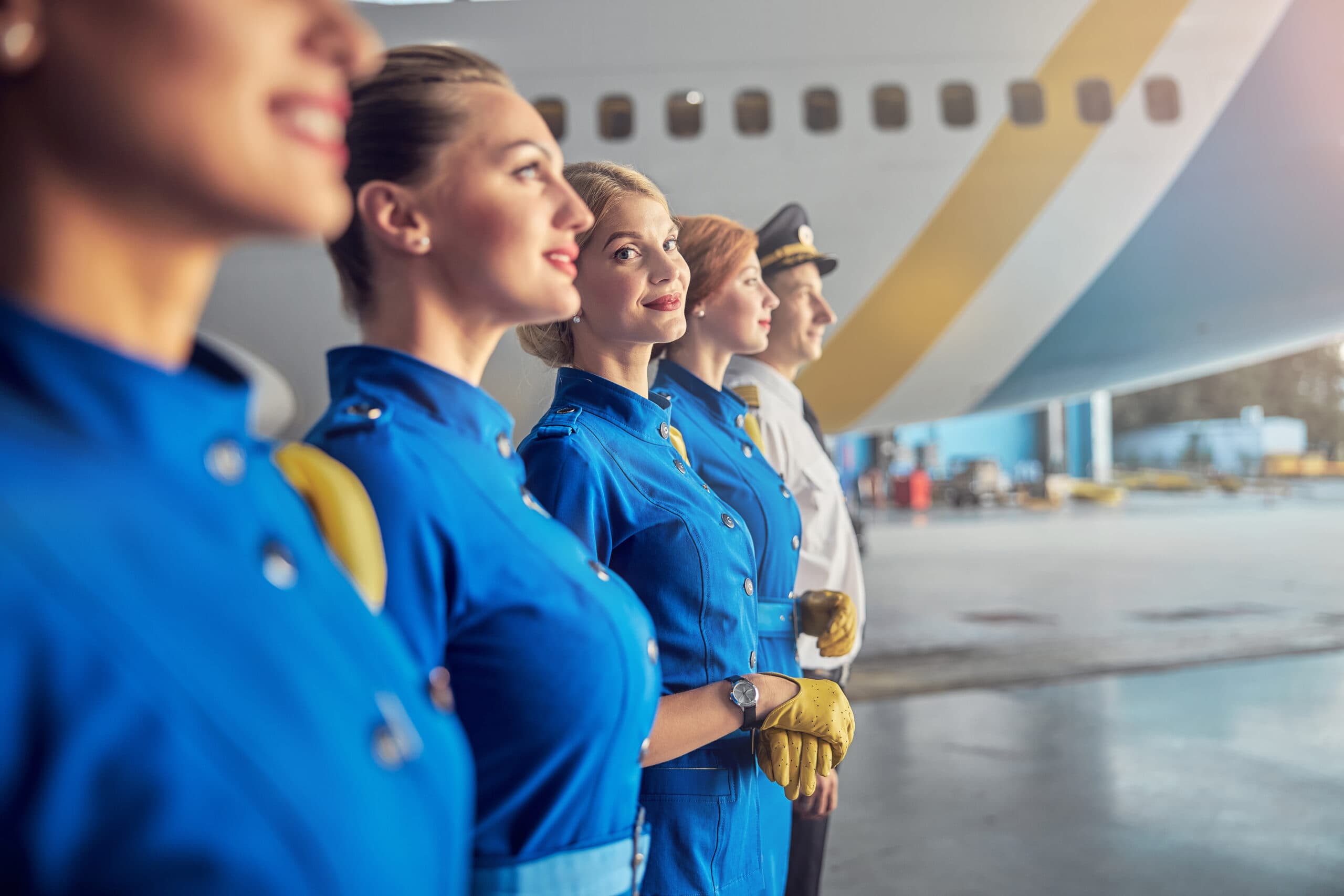 Smiling cabin crew professionals in business attire.